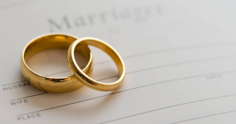 Two gold rings on a marriage certificate.